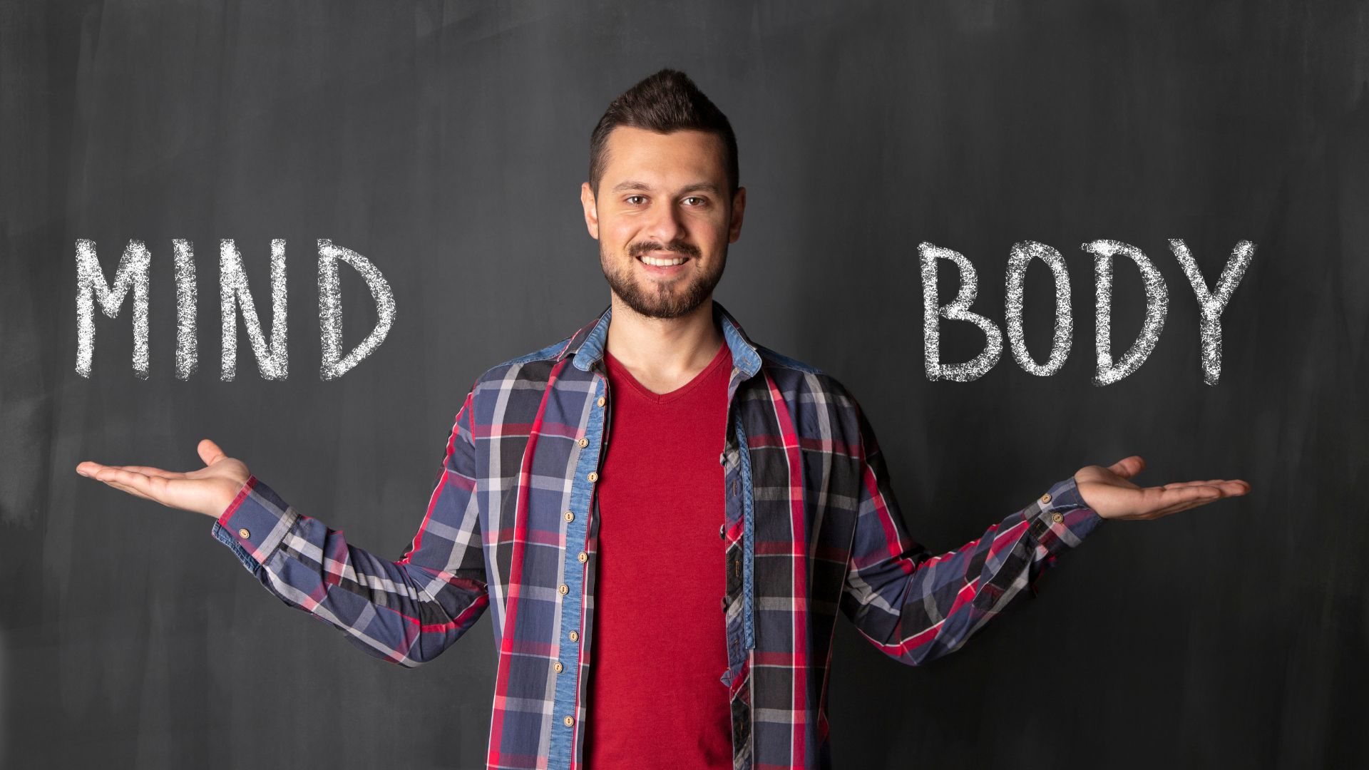 Uomo che indica le scritte "mind" e "body" sulla lavagna