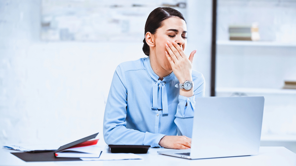 Ragazza che sbadiglia davanti al computer