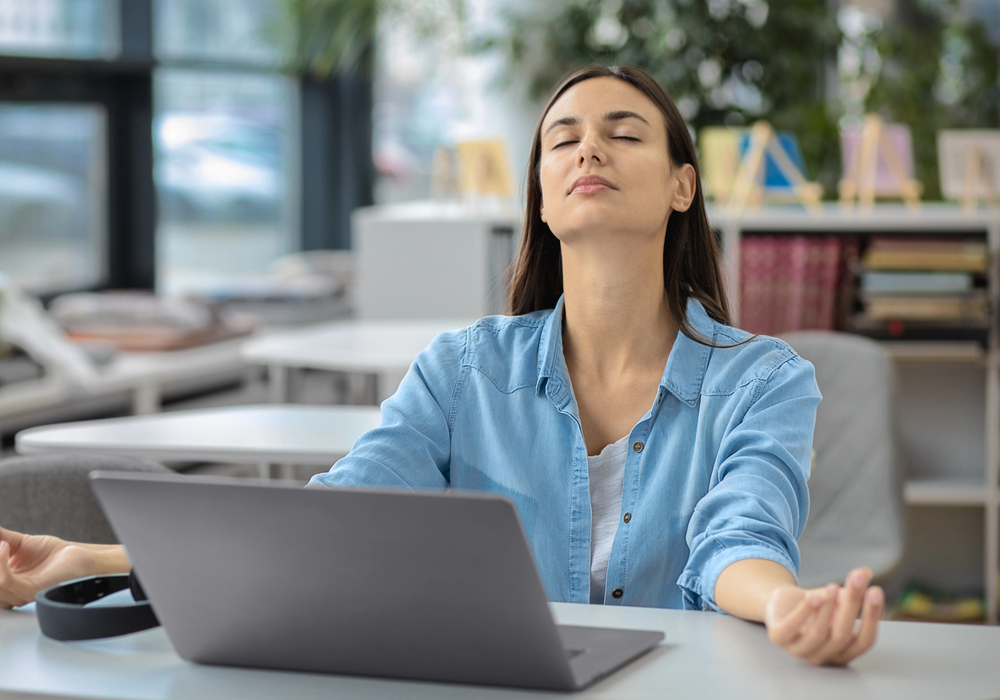 Donna in ufficio che si prende qualche minuti per respirare